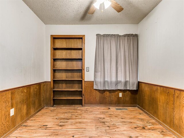 901 Richmond St, Yukon, OK 73099 - unfurnished room featuring wood finished floors, a textured ceiling, wood walls, and wainscoting