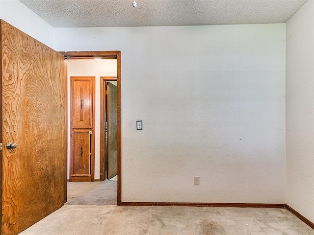 901 Richmond St, Yukon, OK 73099 - unfurnished room featuring baseboards, a textured ceiling, and light colored carpet