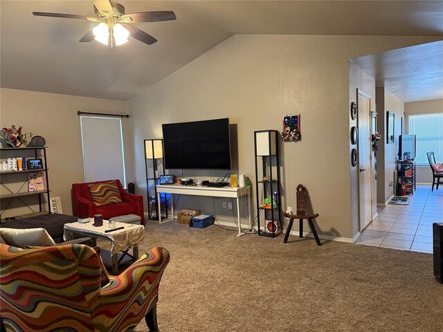 living room featuring a ceiling fan, light tile patterned flooring, light carpet, and lofted ceiling