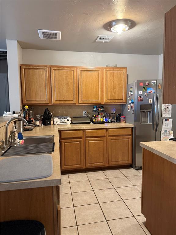 kitchen featuring a sink, light countertops, visible vents, and light tile patterned floors