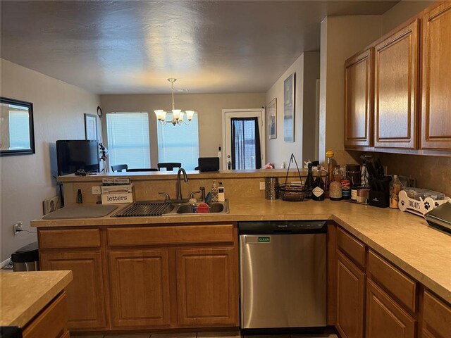 kitchen with a notable chandelier, a sink, a peninsula, brown cabinetry, and stainless steel dishwasher