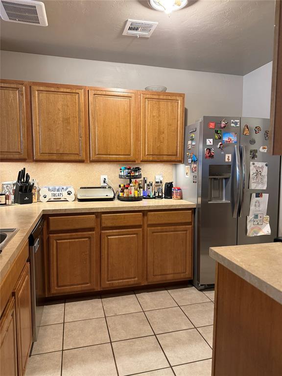 kitchen with brown cabinets, visible vents, light countertops, and stainless steel appliances