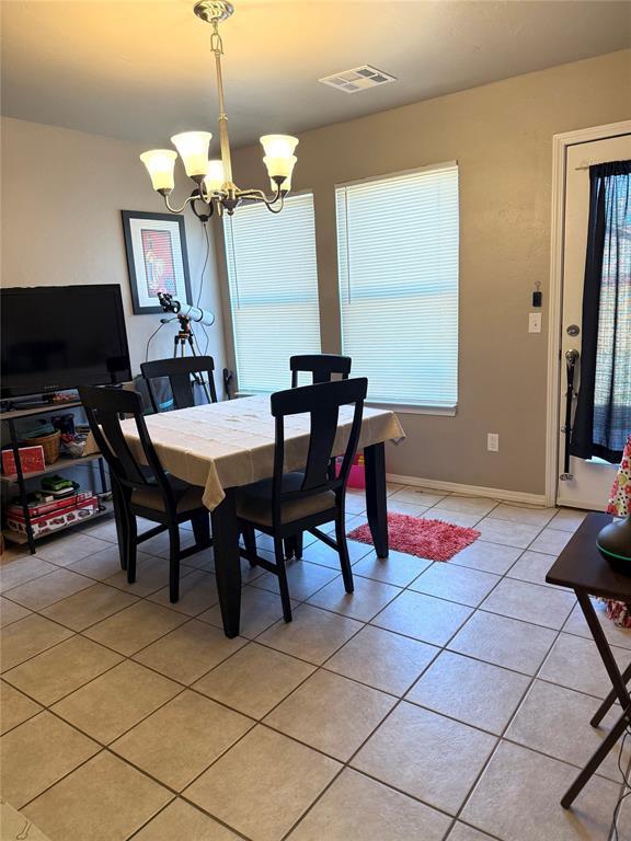 dining area with a chandelier, light tile patterned floors, visible vents, and a healthy amount of sunlight