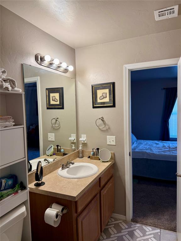 bathroom featuring vanity, visible vents, toilet, and ensuite bathroom