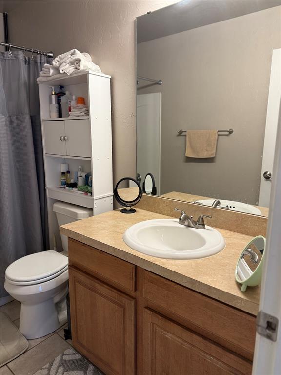 full bath with tile patterned flooring, toilet, a shower with shower curtain, and vanity