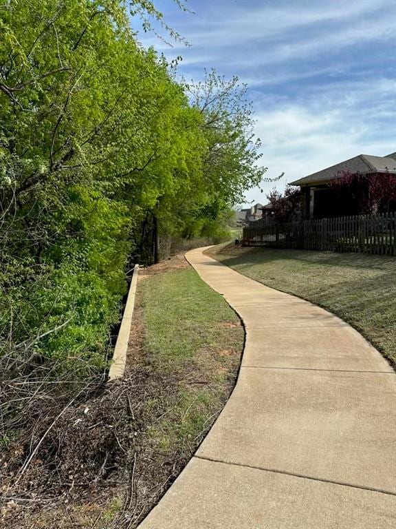 view of home's community with a yard and fence