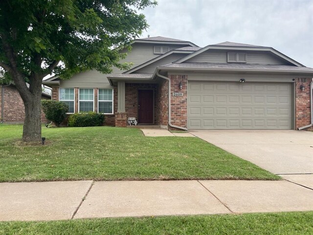 2609 Fennel Rd, Oklahoma City, OK 73128 - view of front of home featuring brick siding, an attached garage, a front lawn, and driveway