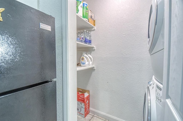 3003 River Oaks Dr Unit 215, Norman, OK 73072 - detailed view of freestanding refrigerator, stacked washer / dryer, and stucco siding