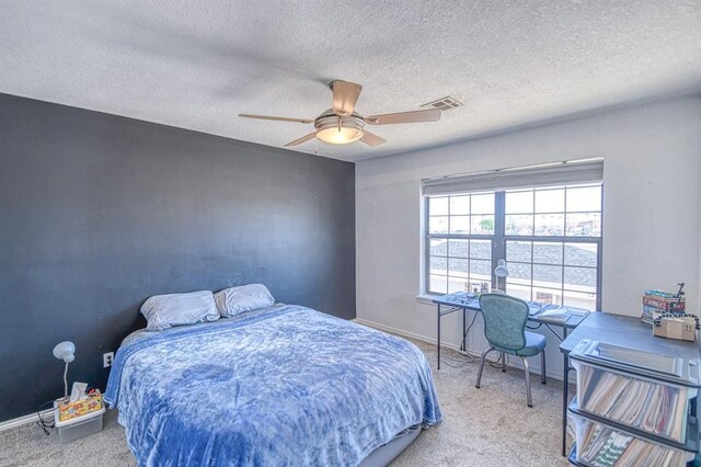 3003 River Oaks Dr Unit 215, Norman, OK 73072 - bedroom with carpet flooring, a textured ceiling, ceiling fan, and baseboards