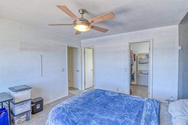 3003 River Oaks Dr Unit 215, Norman, OK 73072 - bedroom featuring carpet flooring, a spacious closet, a textured ceiling, and ceiling fan