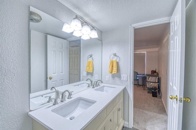 3003 River Oaks Dr Unit 215, Norman, OK 73072 - bathroom featuring a textured ceiling, double vanity, and a textured wall