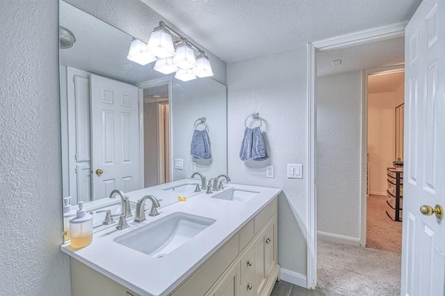 3003 River Oaks Dr Unit 215, Norman, OK 73072 - full bathroom with a textured wall, a textured ceiling, baseboards, and double vanity