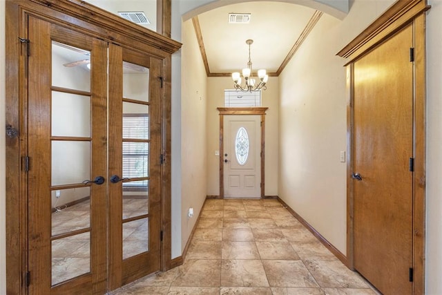 18395 Wild Horse Trl, Norman, OK 73072 - entryway with ornamental molding, visible vents, arched walkways, and a chandelier