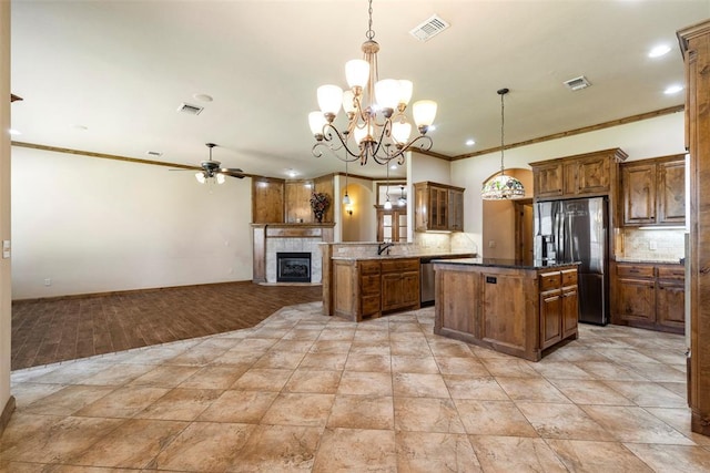 18395 Wild Horse Trl, Norman, OK 73072 - kitchen with backsplash, refrigerator with ice dispenser, a kitchen island, and visible vents