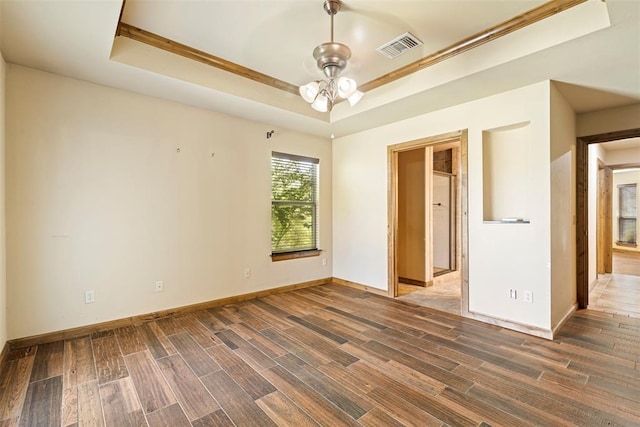 18395 Wild Horse Trl, Norman, OK 73072 - spare room featuring a tray ceiling, baseboards, visible vents, and wood tiled floor