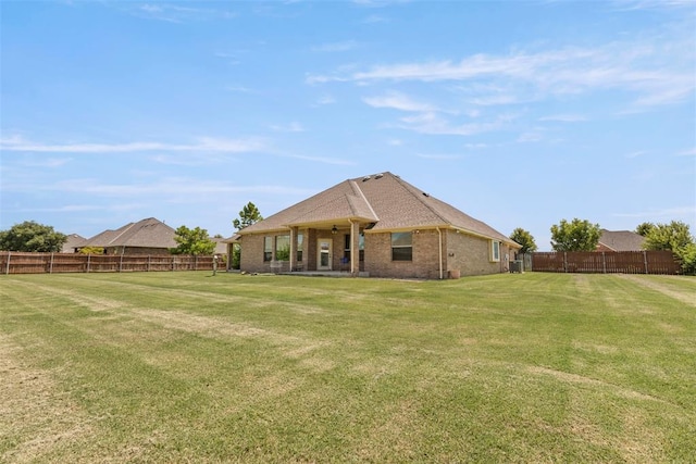 18395 Wild Horse Trl, Norman, OK 73072 - back of house with brick siding, a fenced backyard, and a lawn