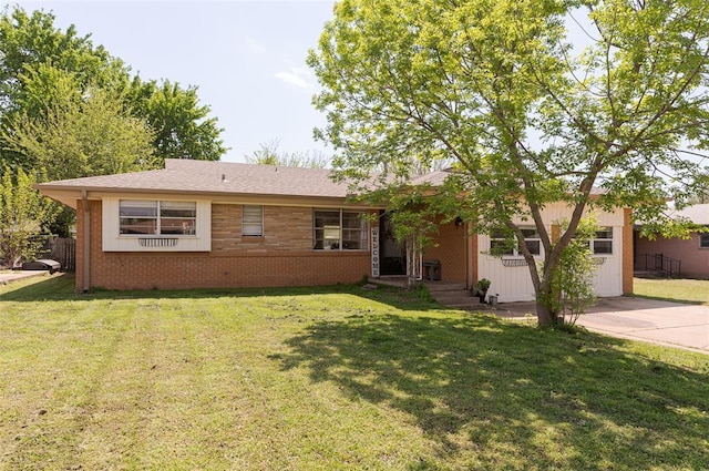 ranch-style house with a front yard and brick siding