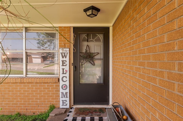 view of exterior entry featuring brick siding