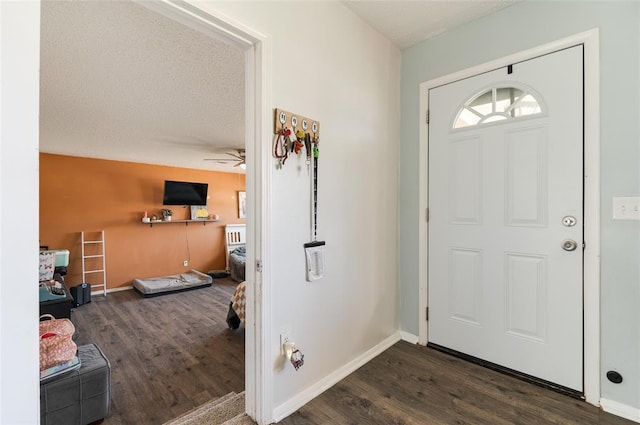 entrance foyer with a textured ceiling, baseboards, and wood finished floors