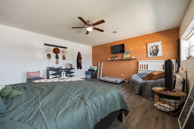 bedroom featuring visible vents, a ceiling fan, wood finished floors, and a textured ceiling