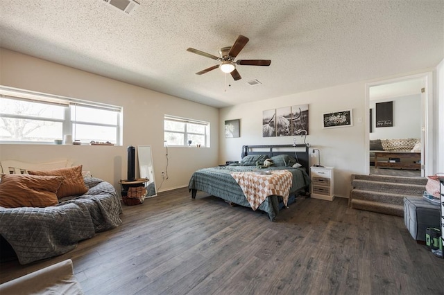 bedroom with a textured ceiling, dark wood-style floors, and visible vents