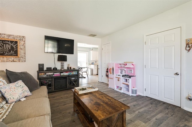 living area featuring dark wood-style flooring and visible vents