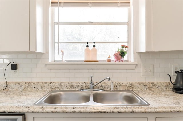 kitchen featuring a sink, light countertops, and white cabinets