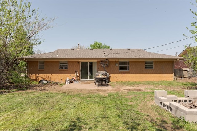 back of house featuring a patio, brick siding, fence, and a lawn