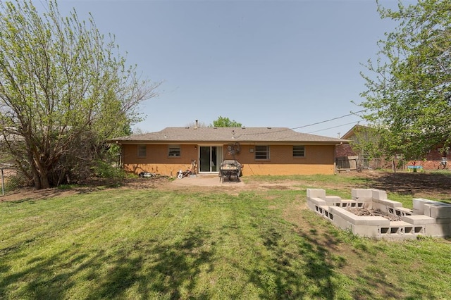back of property featuring brick siding, fence, a lawn, and a patio area