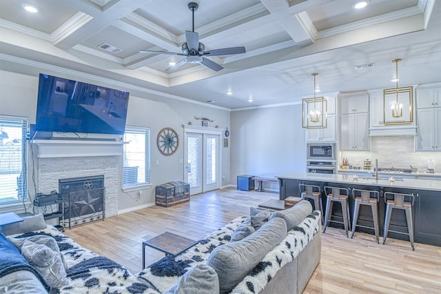 9328 NW 118th St, Yukon, OK 73099 - living room featuring coffered ceiling, light wood finished floors, ornamental molding, and visible vents