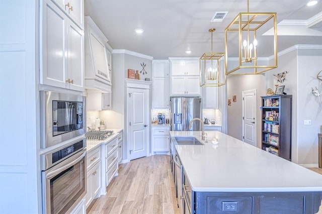 9328 NW 118th St, Yukon, OK 73099 - kitchen with a sink, white cabinets, a notable chandelier, and stainless steel appliances