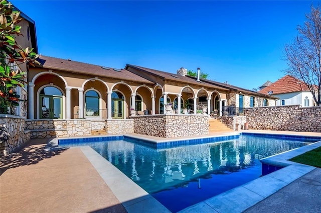 view of swimming pool with french doors, a fenced in pool, and a patio