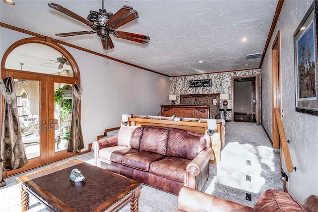 carpeted living area featuring ornamental molding, a ceiling fan, visible vents, french doors, and baseboards