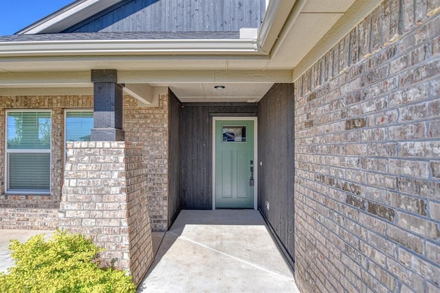 doorway to property with brick siding