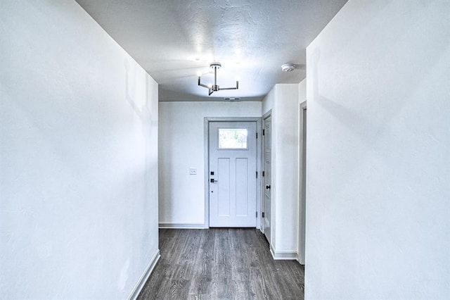 doorway to outside featuring wood finished floors and baseboards