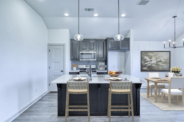 kitchen featuring light countertops, stainless steel appliances, light wood-style flooring, and visible vents