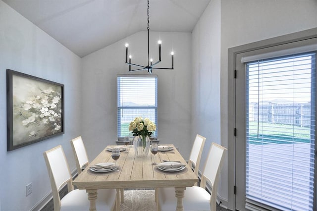 dining space with a chandelier and lofted ceiling