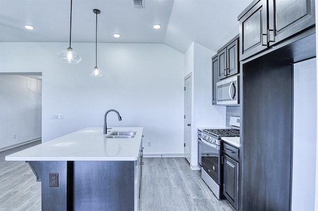 kitchen featuring a sink, appliances with stainless steel finishes, visible vents, baseboards, and light wood-style floors