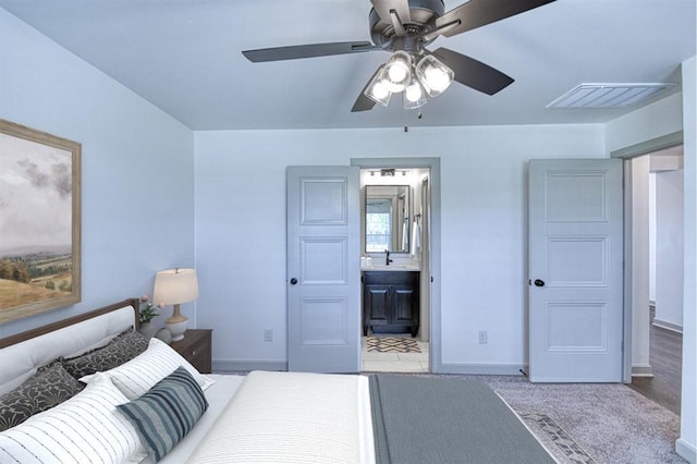 carpeted bedroom with visible vents, baseboards, ceiling fan, and a sink