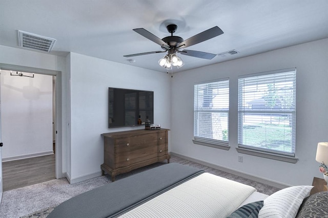 carpeted bedroom featuring baseboards, visible vents, and a ceiling fan