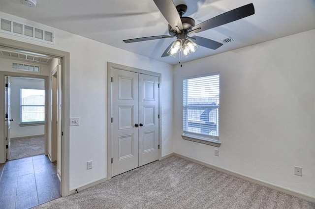unfurnished bedroom with multiple windows, visible vents, and light colored carpet