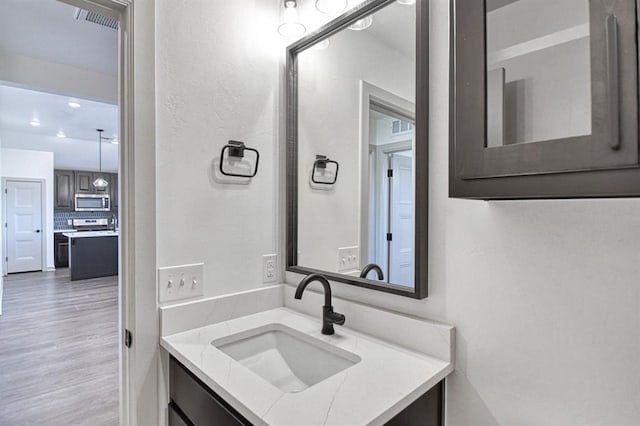 bathroom featuring visible vents, wood finished floors, and vanity