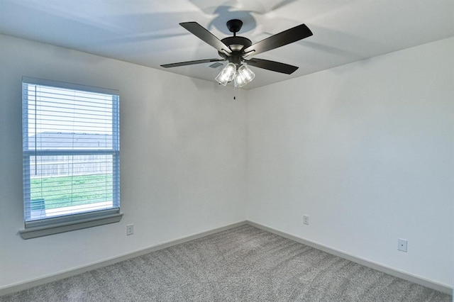 spare room featuring light carpet, baseboards, and plenty of natural light