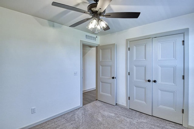 unfurnished bedroom featuring a closet, visible vents, light carpet, a ceiling fan, and baseboards