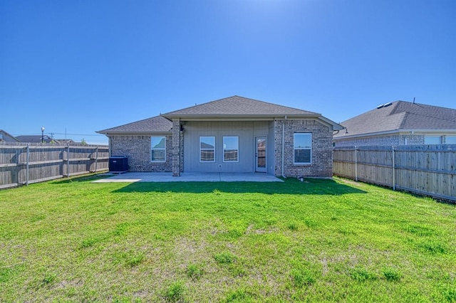 back of property with a lawn, a patio area, cooling unit, and a fenced backyard