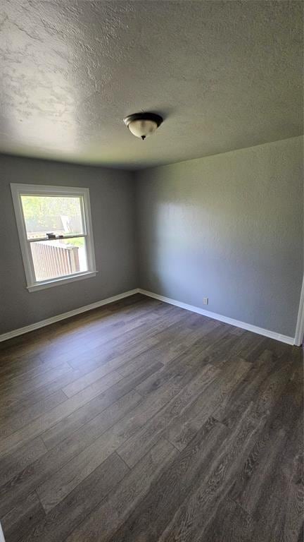 1708 NE 47th St, Oklahoma City, OK 73111 - unfurnished room featuring baseboards, a textured ceiling, and dark wood-style floors