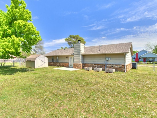 2416 Ellis Dr, Shawnee, OK 74804 - rear view of house with an outdoor structure, a chimney, a shed, fence, and a lawn