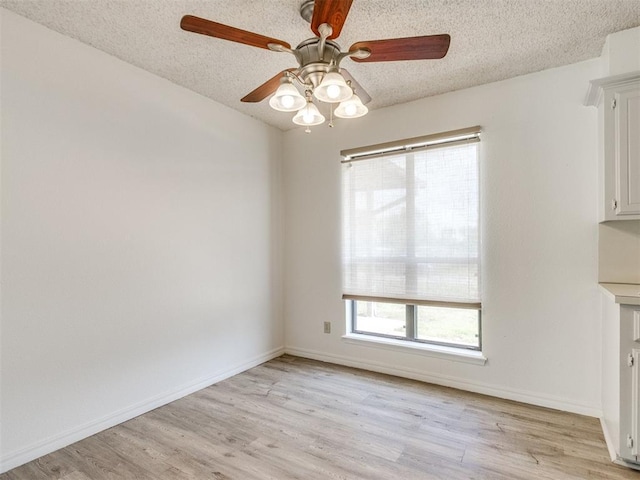 2416 Ellis Dr, Shawnee, OK 74804 - unfurnished dining area featuring light wood-style flooring, a textured ceiling, baseboards, and ceiling fan