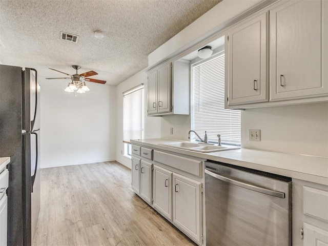 2416 Ellis Dr, Shawnee, OK 74804 - kitchen featuring light countertops, freestanding refrigerator, a ceiling fan, dishwasher, and a sink