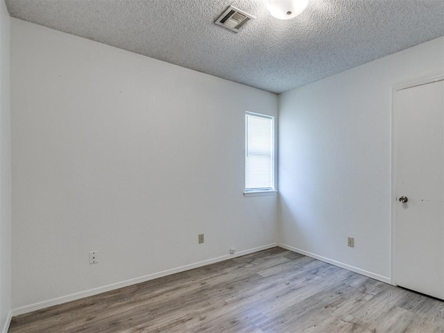 2416 Ellis Dr, Shawnee, OK 74804 - unfurnished room featuring a textured ceiling, wood finished floors, baseboards, and visible vents